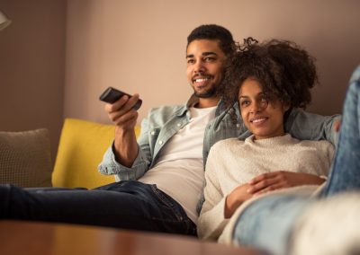 Couple watching tv in an affordable apartment in Wilmington, DE.